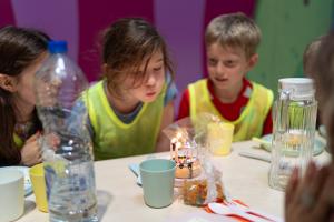 Enfant qui souffle ses bougies lors d’un anniversaire au parc Chibitopia